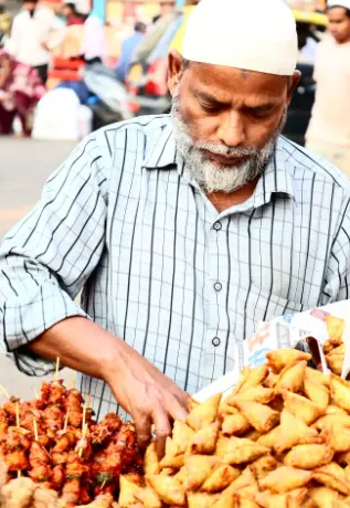 Street food vendor arranging samosas