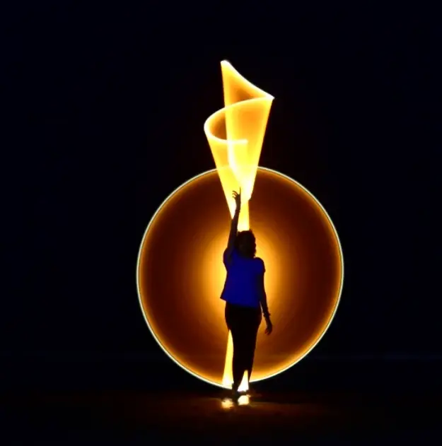 Silhouette surrounded by sweeping light trails